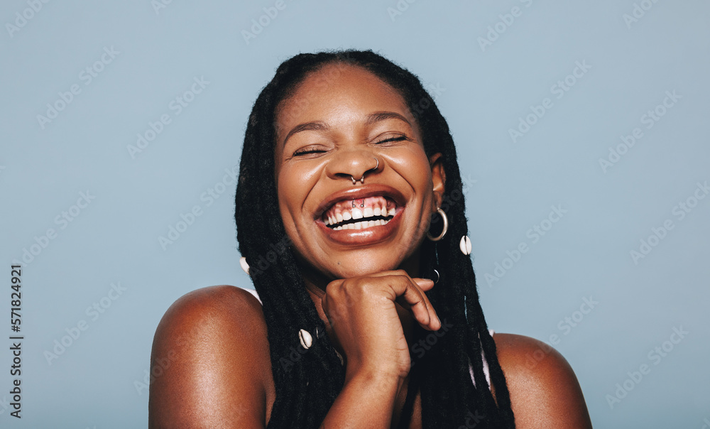 African woman with face piercings smiling cheerfully in a studio