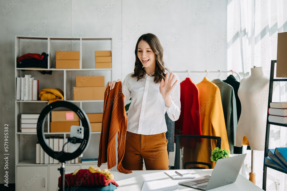 Fashion blogger concept, Young Asian women selling clothes on video streaming.Startup small business