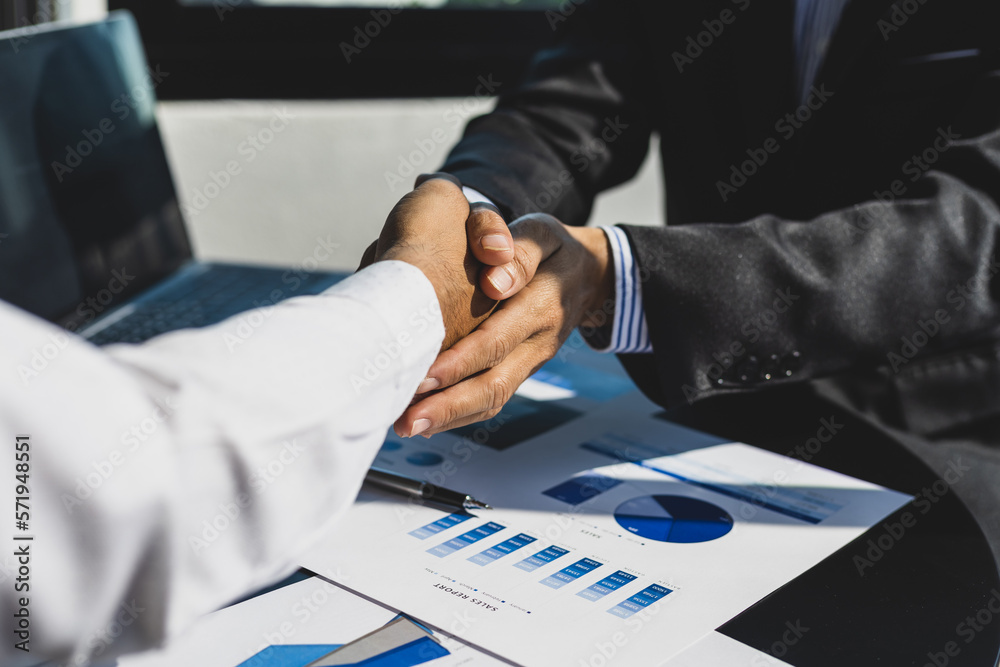 Handshake. Businessman on desk shaking hands with accountant or financial advisor in office.