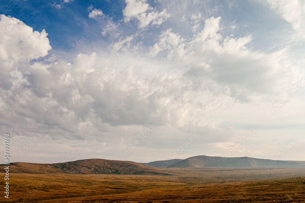 Altai mountain valley autumn withering grass. blue sky with white clouds