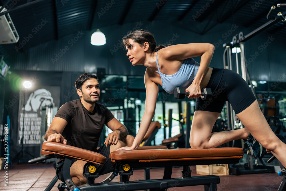 Caucasian fitness trainer motivate young sportswoman to exercise in gym