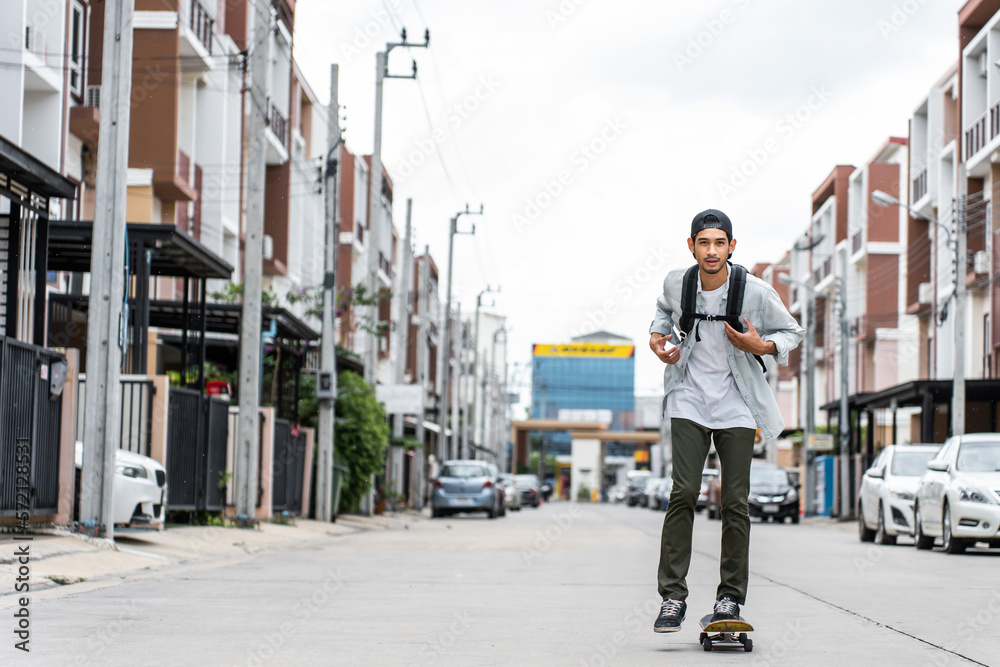 Asian young male ride surf skate board on street on the way to work. 