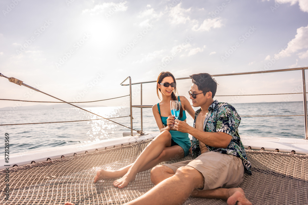 Asian beautiful couple drinking champagne while having party in yacht. 