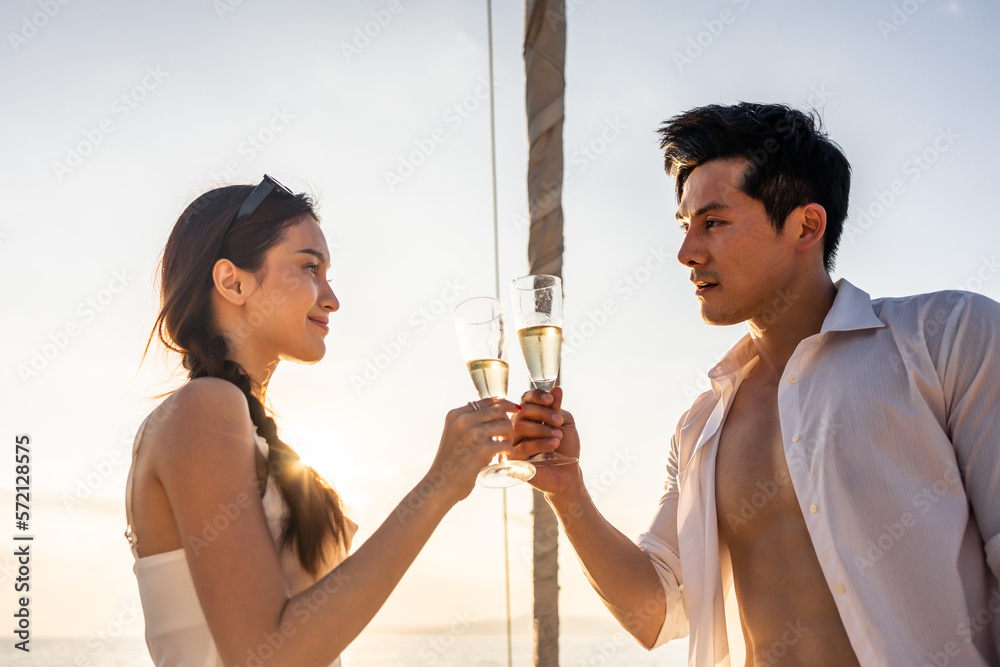 Asian beautiful couple drinking champagne while having party in yacht. 