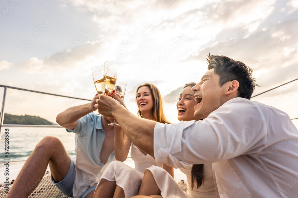 Group of diverse friends drink champagne while having a party in yacht