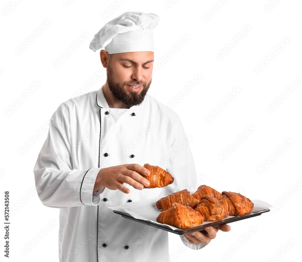 Male baker with tray of tasty croissants on white background