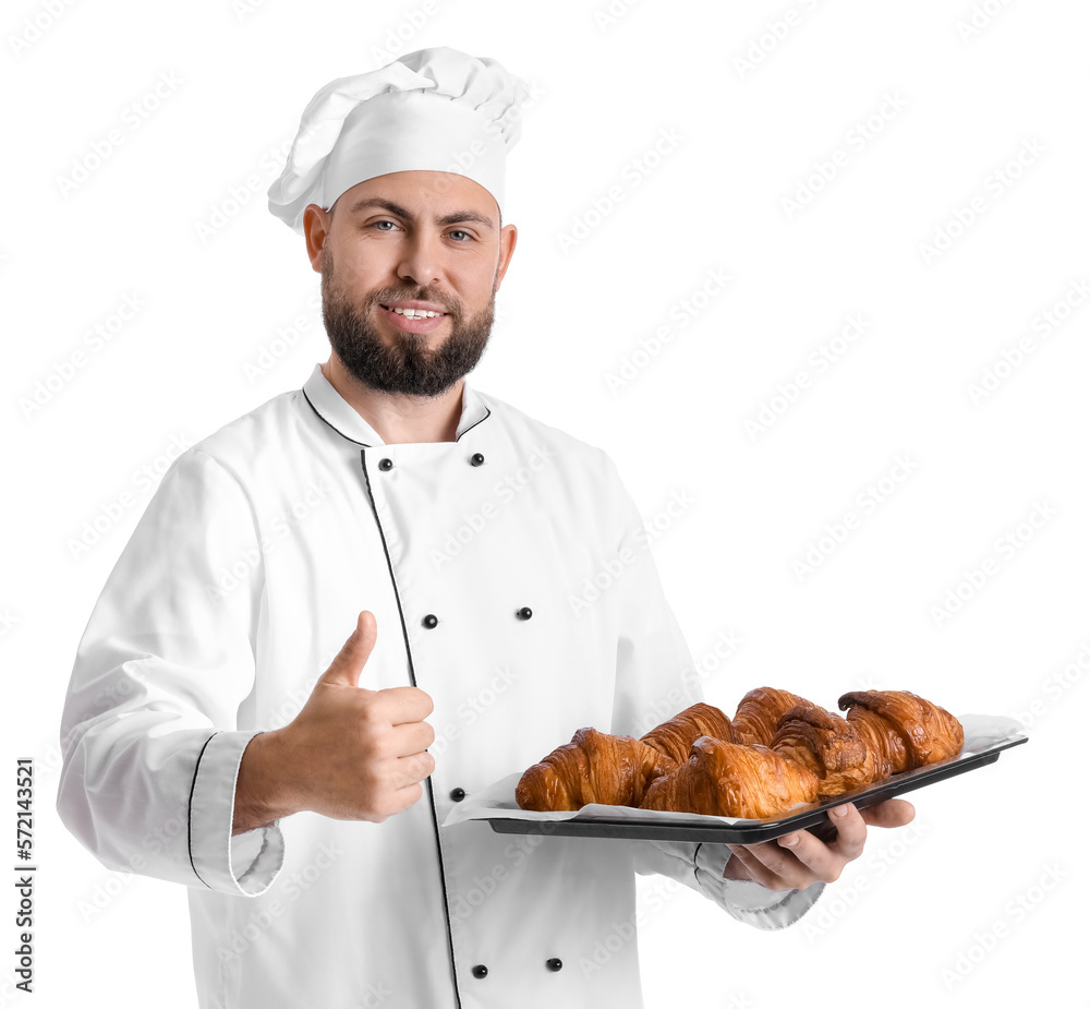 Male baker with tray of tasty croissants showing thumb-up on white background