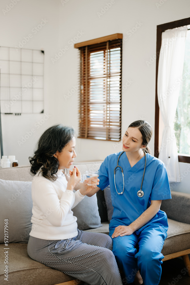 Asian female hands touching old female hand Helping hands holding bottle with pills in hands, readin