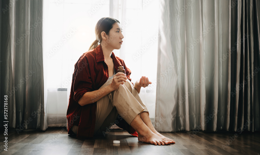  woman sit Depression Dark haired  pensive glance Standing with glass of water and pills by window a