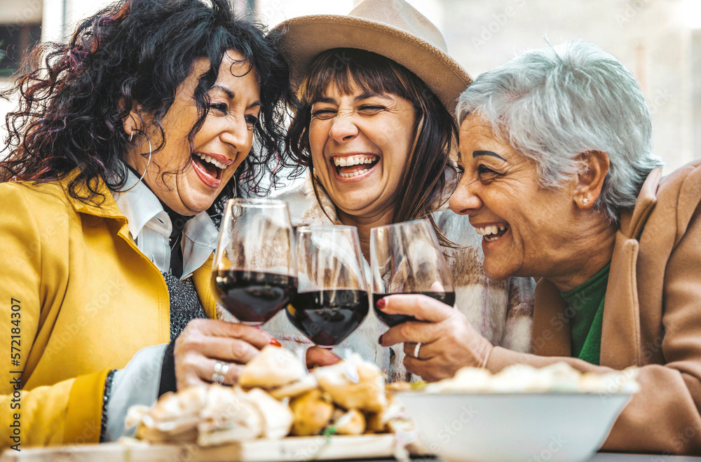 Happy senior women drinking red wine at bar restaurant - Mature people having fun hanging out on cit