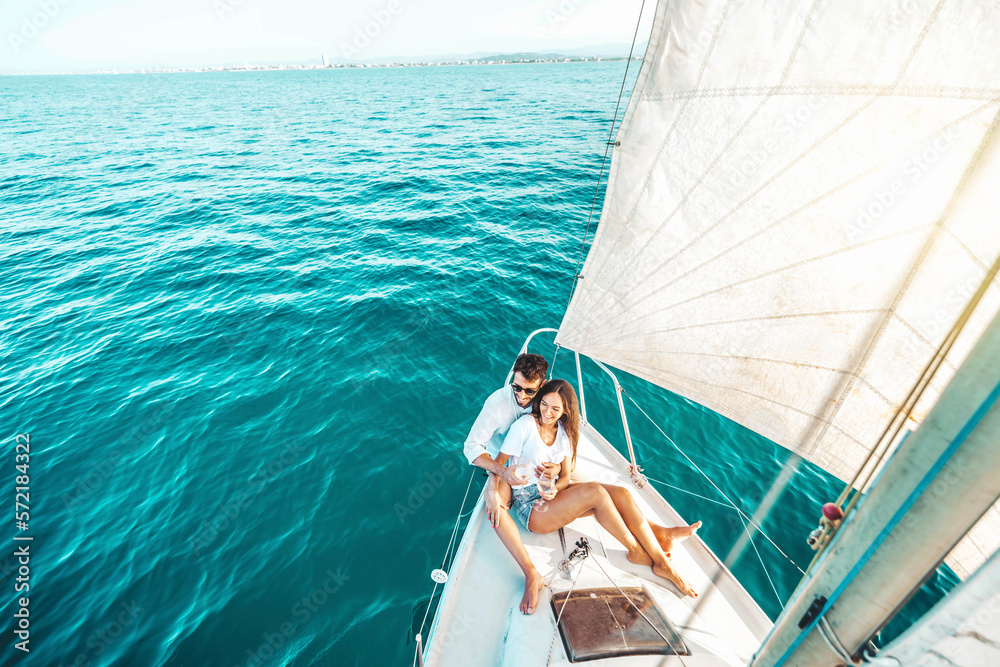 Young couple relaxing on yacht cruise - Two lovers enjoying summer vacation experience on sail boat 