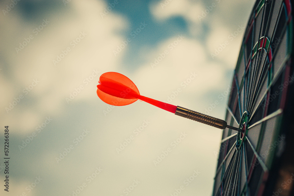 Close up shot of the dart arrow hit on bulleyes of dartboard to represent that the business reached 