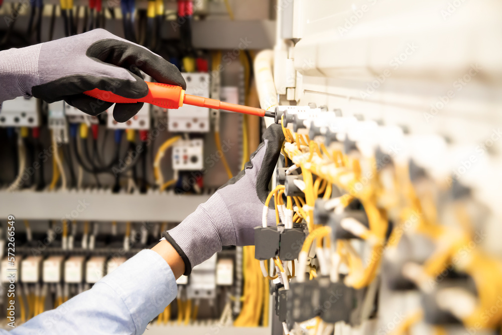 Electricians work to connect electric wires in the system, switchboard, electrical system in Control