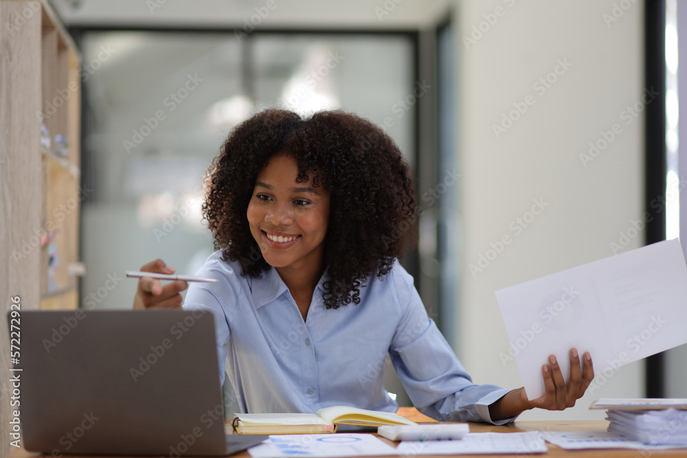 Happy african american businesswoman smiling and laughing from working on a successful project.