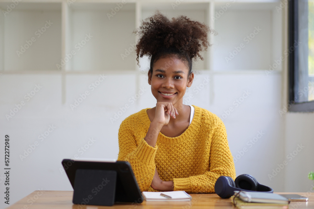 Portrait of a happy african woman in her home office.