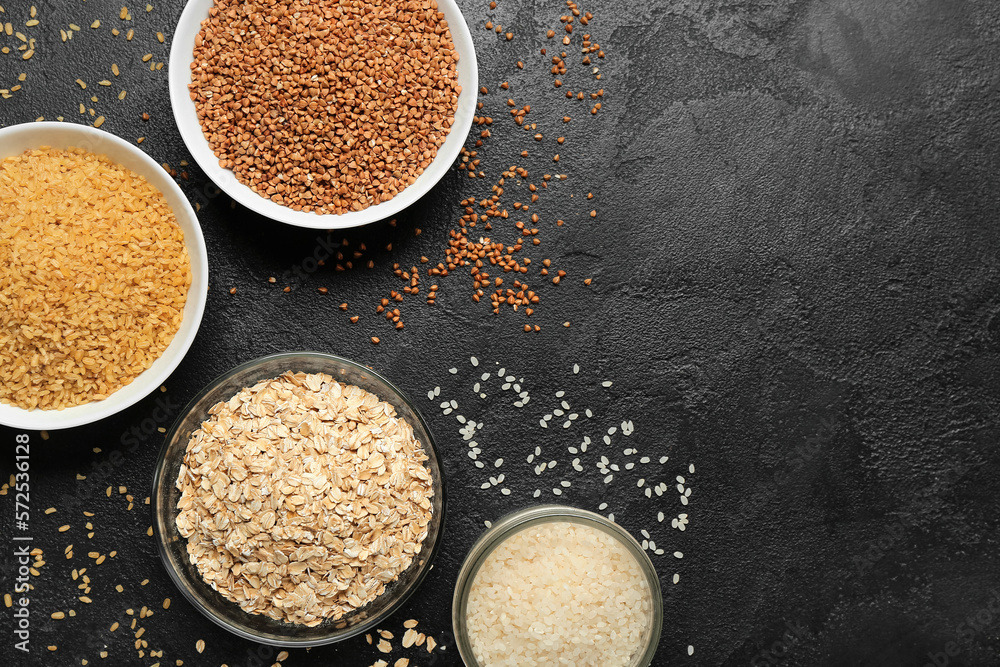 Bowls of different cereals on dark background