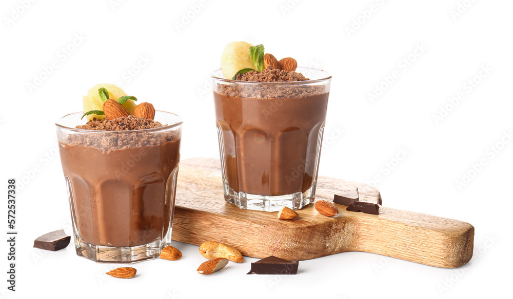 Board with glasses of chocolate pudding, almond and banana slice isolated on white background