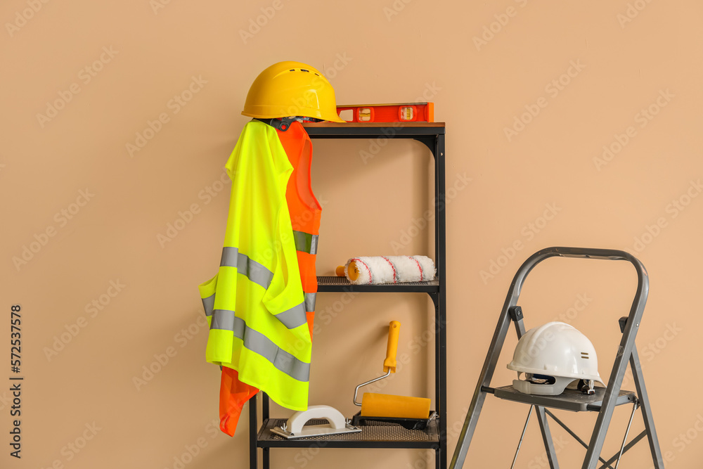 Stepladder and shelving unit with builders equipment near beige wall