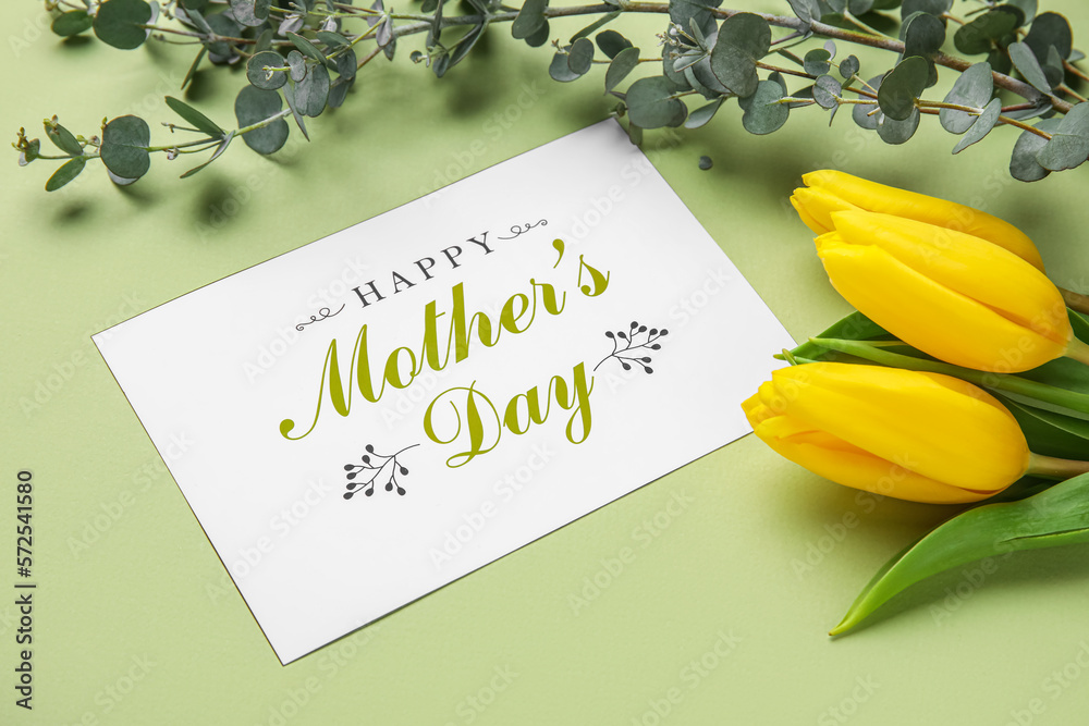 Card with text HAPPY MOTHERS DAY, tulip flowers and eucalyptus branches on green background, closeu