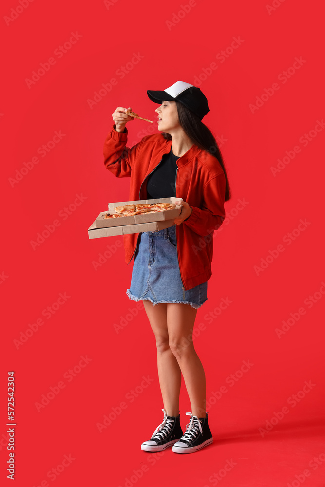 Young woman with box of tasty pizza on red background