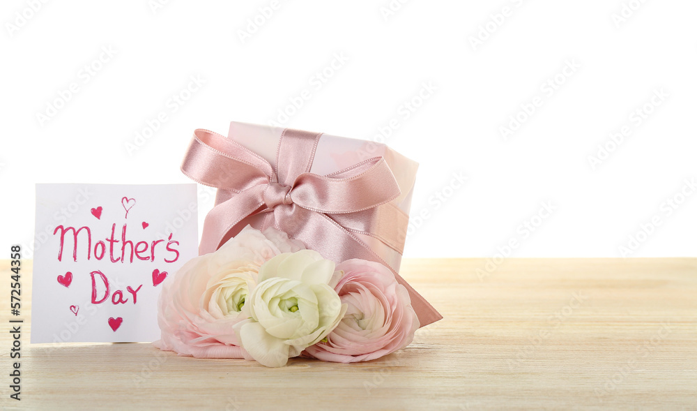 Greeting card with text MOTHERS DAY, flowers and gift on table against white background