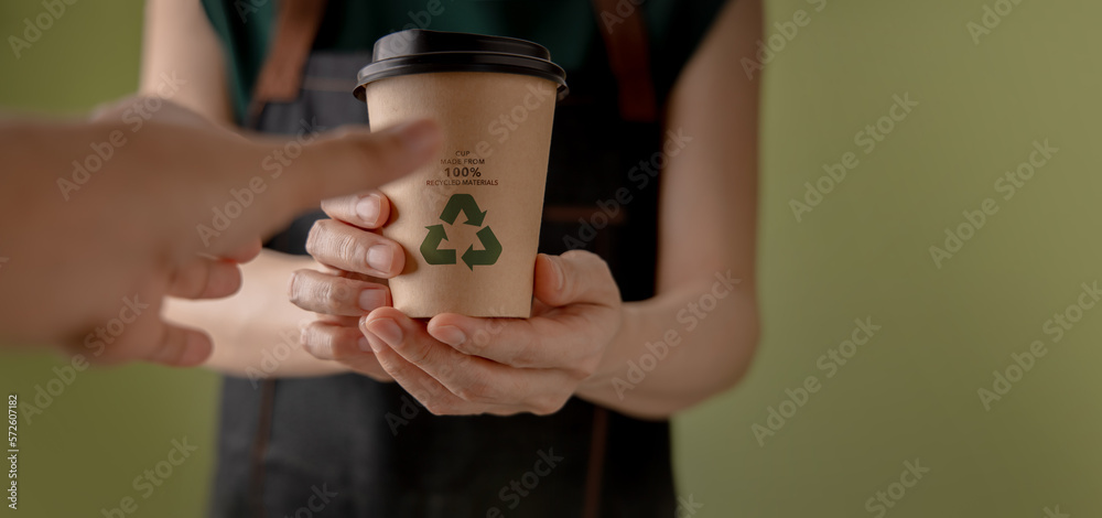 Recycled Packaging Concept. Barista Giving a Hot Cup of Coffee to customer. Zero Waste Materials. En