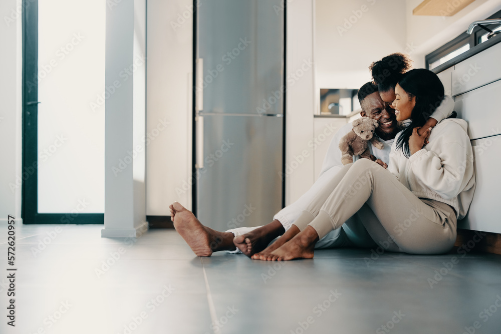 Sweet family moments at home, mom and dad sitting on the floor with their daughter