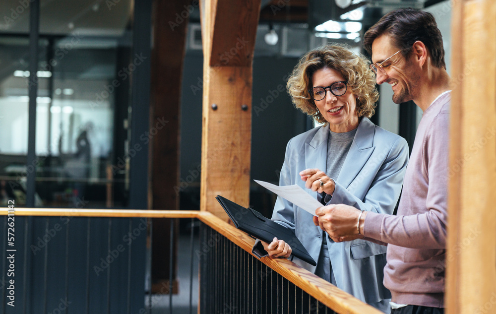 Business people analysing a financial report together. Two business people discussing in an office