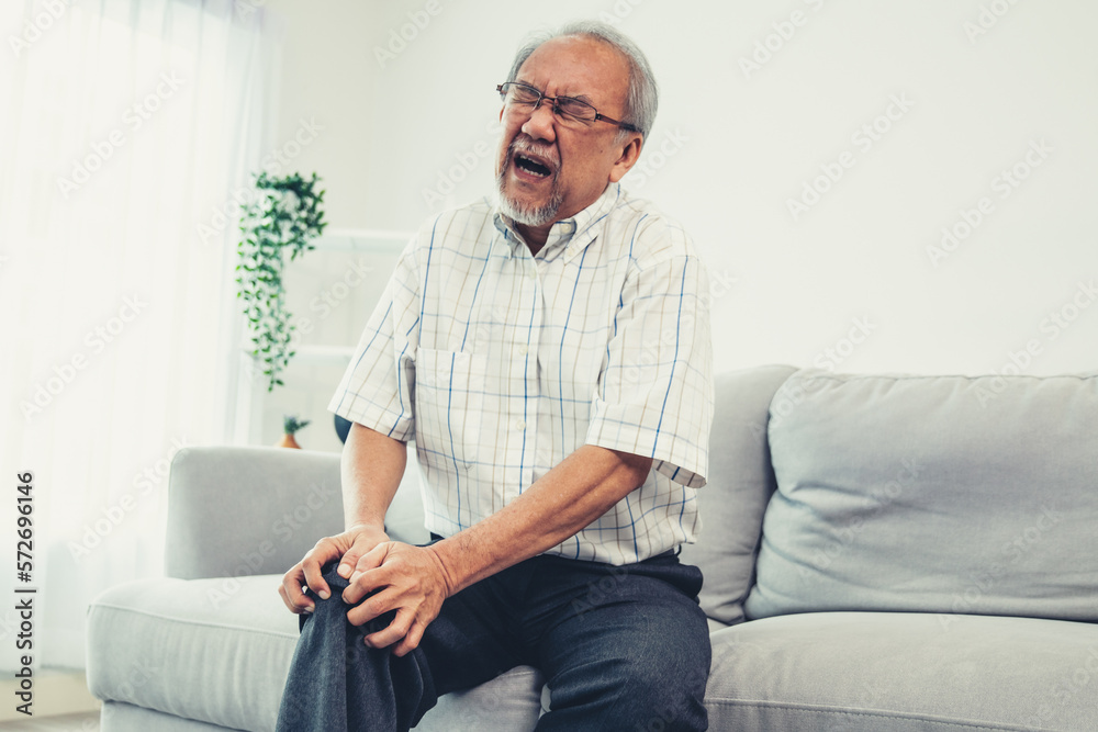 Close up image of an agonizing senior man with knee problem, pain, and ache while attempting to disp