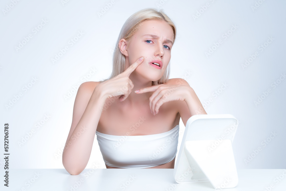 Acne problem troubling personable worried woman with natural beauty skin checking her face squeezing