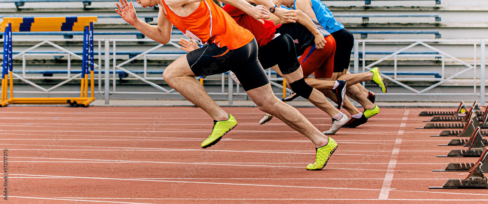 start sprint men runners run 100 meters at stadium