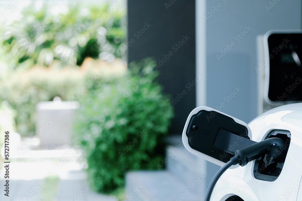 Closeup electric vehicle plugged-in with cable from charging point powered for progressive concept b