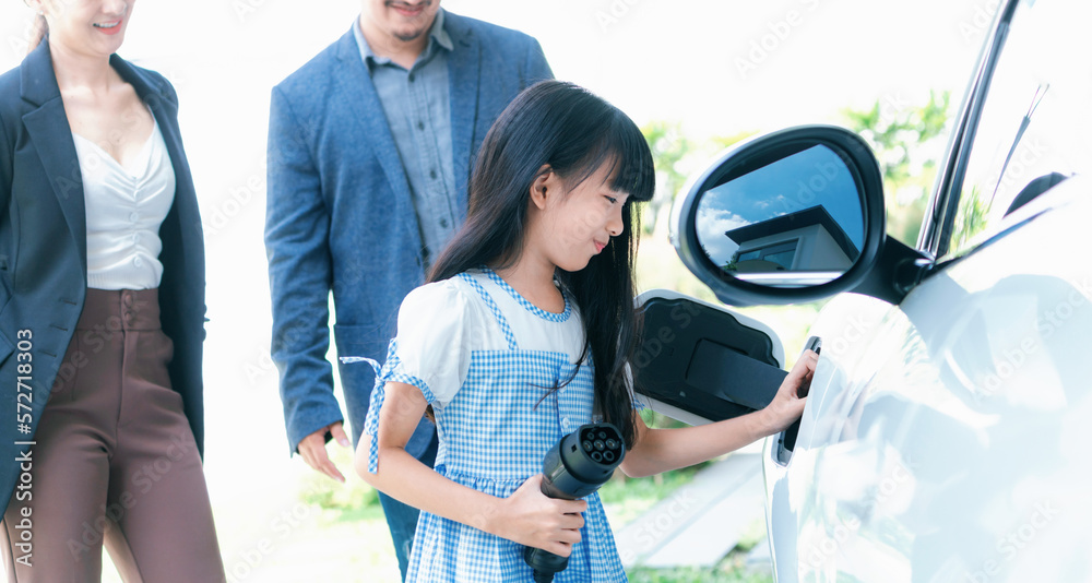 Focus closeup electric vehicle recharging battery from home electric charging station with blurred f