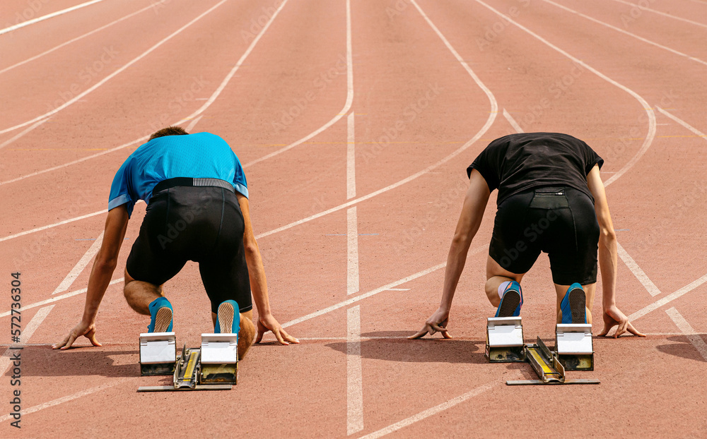 runners athletes in starting blocks for 100 meters race