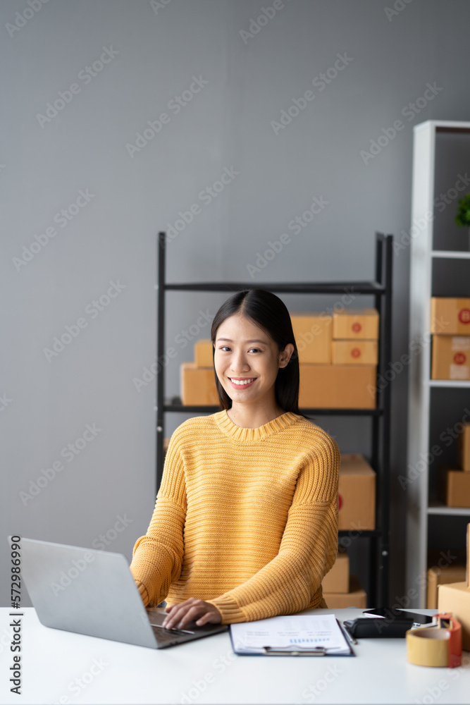 Portrait of young Asian small business owner working in her room while using laptop computer. Sme bu