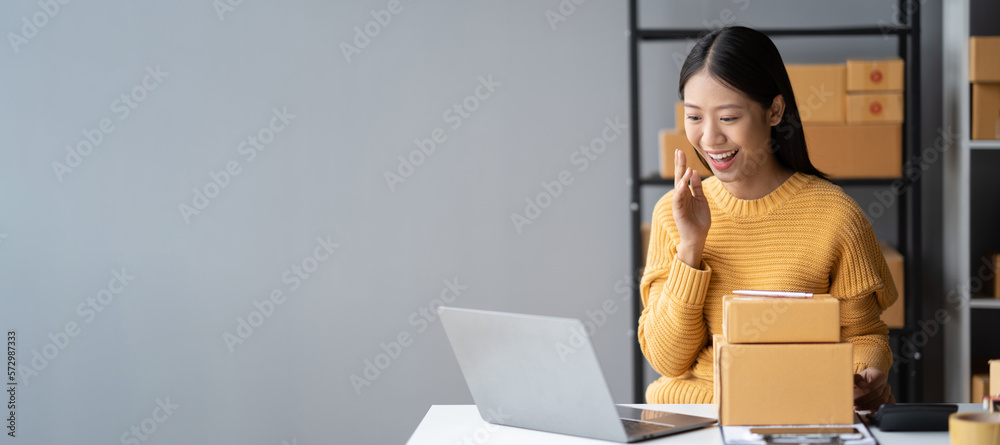 Portrait of young beautiful sme small online business owner sitting in her room with parcel box, rea