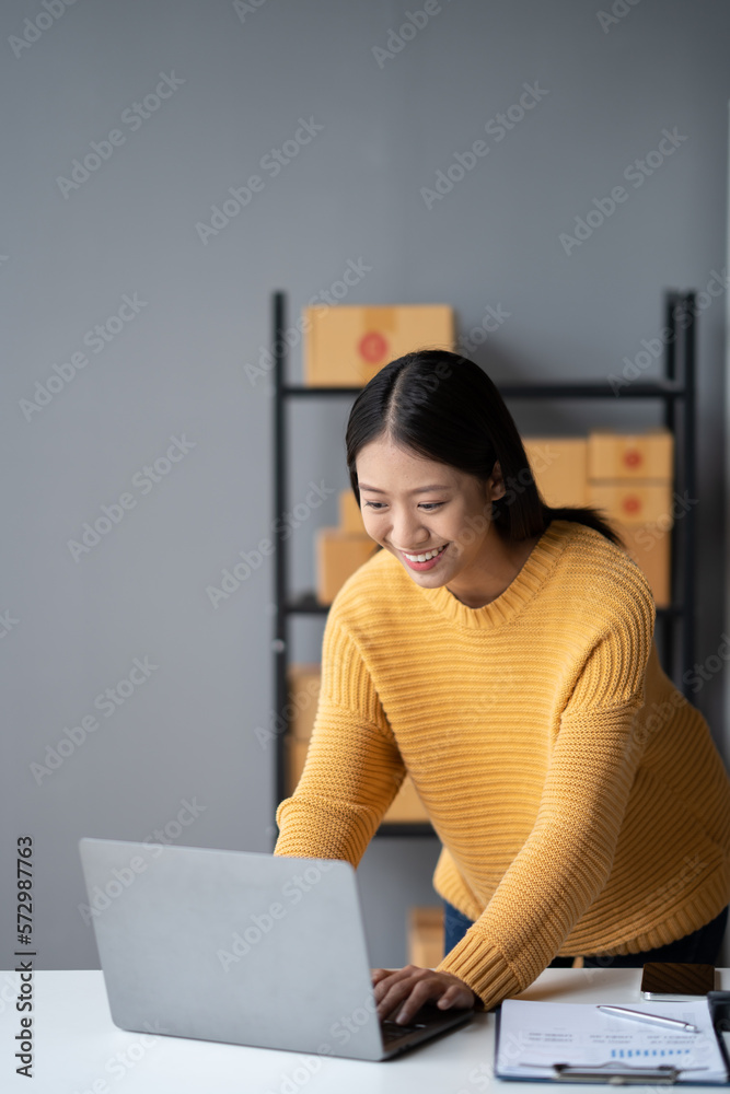 Portrait of young Asian small business owner working in her room while using laptop computer. Sme bu