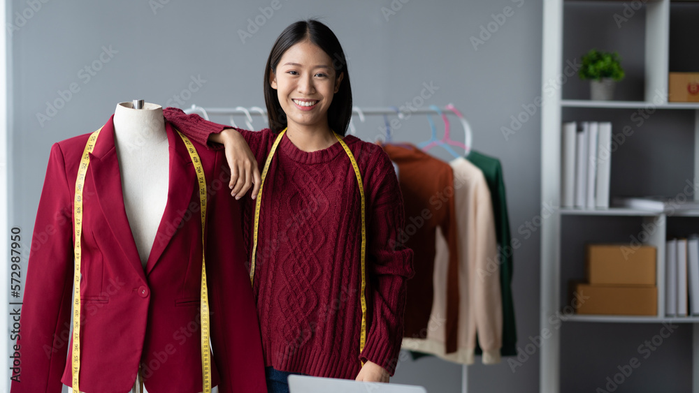 Young confident Asian woman who own cloth shop standing in her studio while measuring the size for h