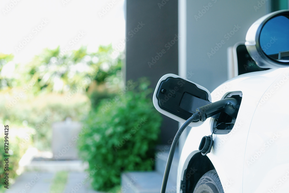 Closeup electric vehicle plugged-in with cable from charging point powered for progressive concept b