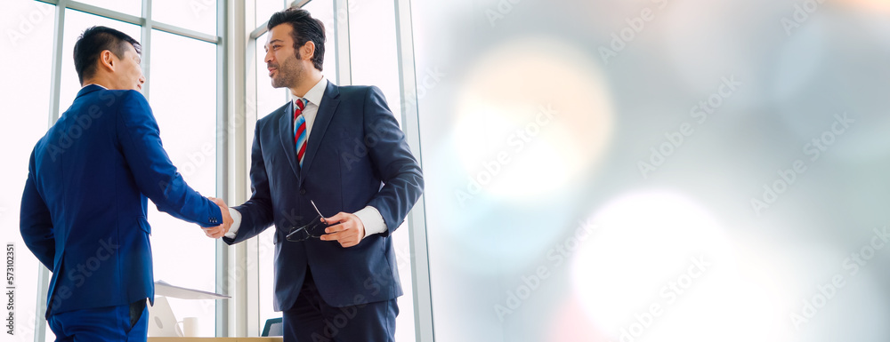 Business people handshake in corporate office in widen view showing professional agreement on a fina