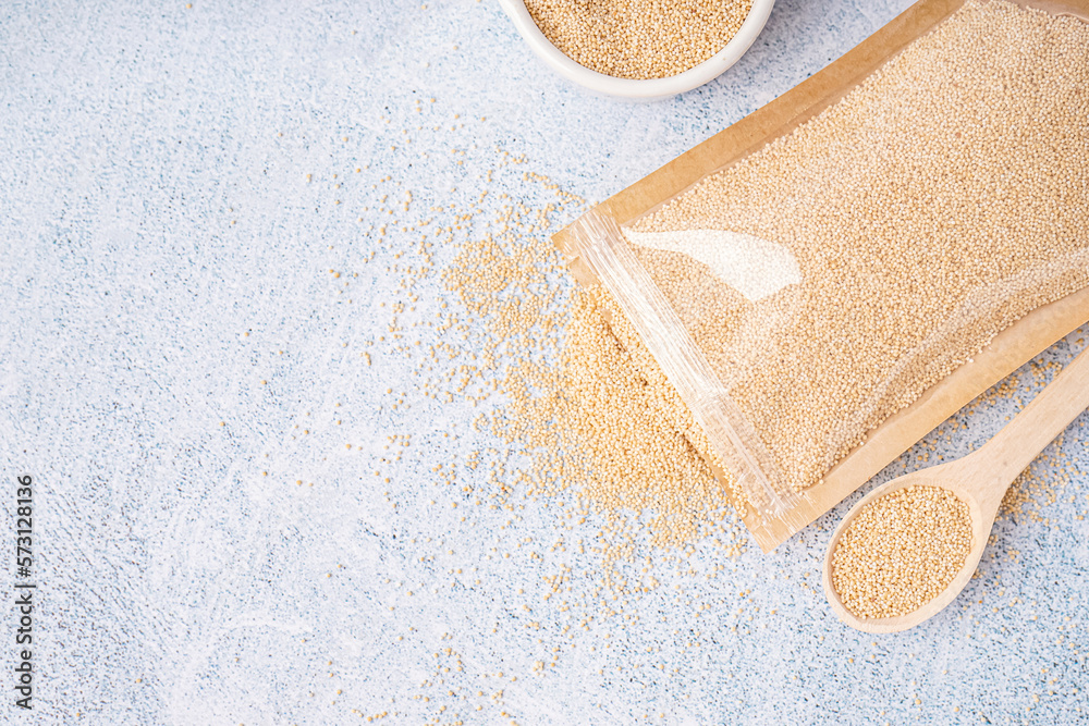 Paper bag, spoon and bowl on light background