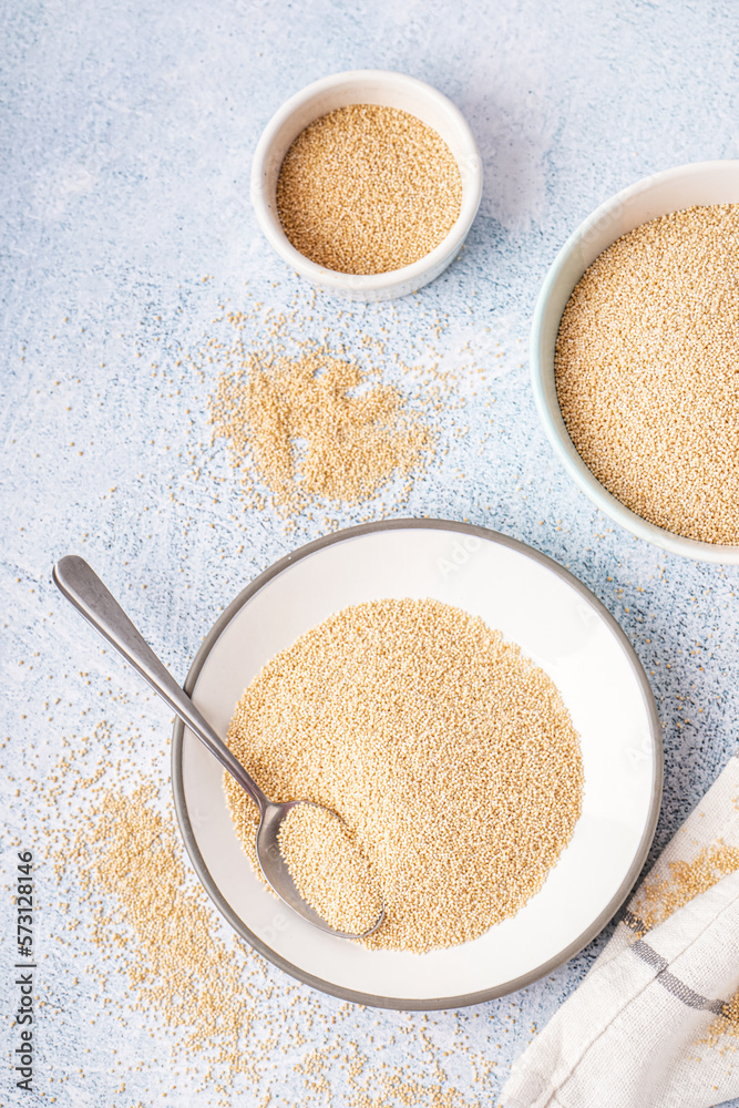 Bowls of amaranth seeds on light background