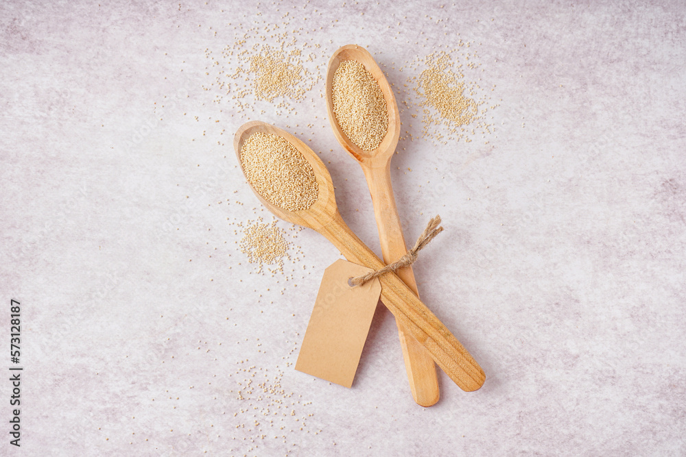 Wooden spoons of amaranth seeds on light background