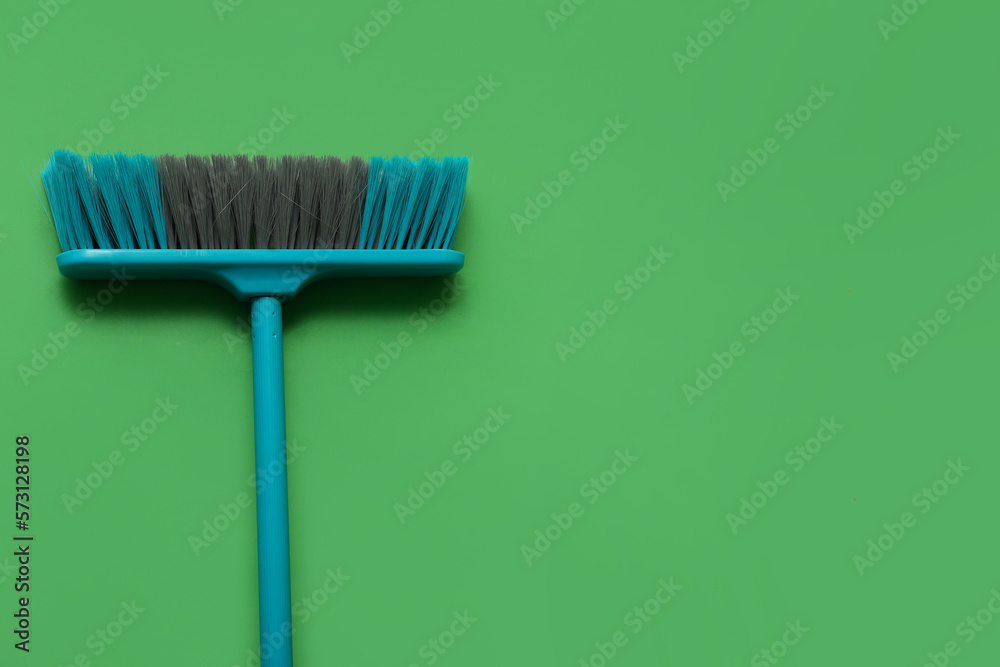 Blue cleaning broom on green background