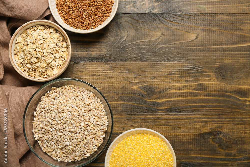 Bowls with cereals on wooden background