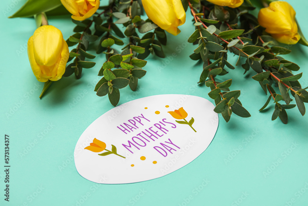 Card with text HAPPY MOTHERS DAY, eucalyptus branches and tulip flowers on color background, closeu