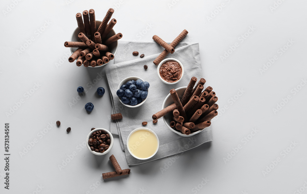 Composition with delicious chocolate wafer rolls, blueberries, condensed milk and coffee beans on gr