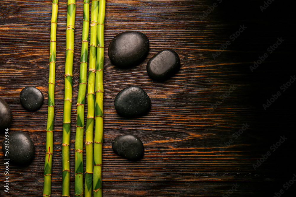 Spa stones and bamboo on wooden background, top view