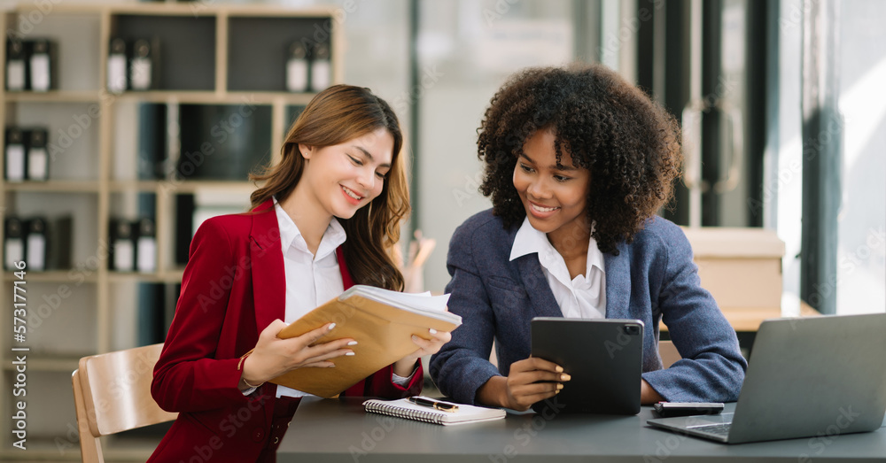 Two businesswoman discuss investment project working and planning strategy with tablet laptop comput