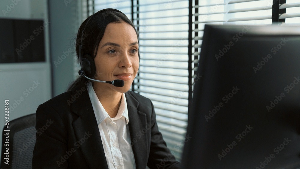 Competent female operator working on computer and talking with clients. Concept relevant to both cal